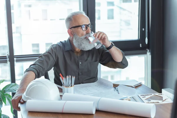 Arquitecto serio en gafas está disfrutando de la bebida — Foto de Stock