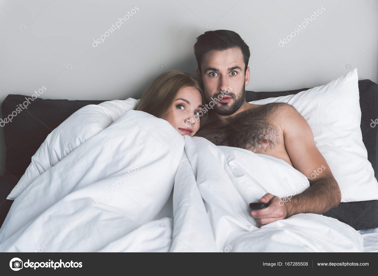 Fearful Man And Woman Entertaining With Television In Bed