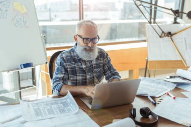 Pozitif hoş yaşlı adam ofisinde çalışıyor