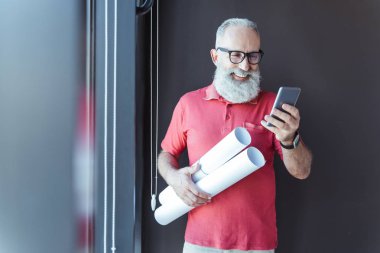 Neşeli yaşlı gri saçlı işadamı cep telefonu kullanıyor
