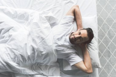 çekici bir genç adam yatakta rahatlatıcı