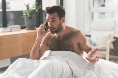 Yatak odasında Smartphone kullanan meşgul adam