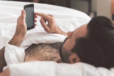 Sakin adam cep telefonu yatmadan gevşeme sırasında holding