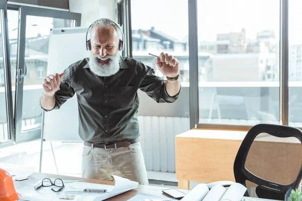 Alegre viejo ingeniero es obtener placer de melodía — Foto de Stock