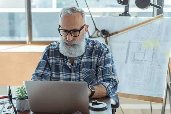Gray-haired senior engineer is using computer — Stock Photo, Image