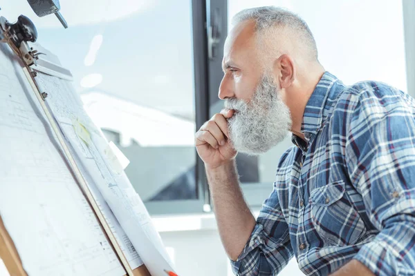 Agradable viejo hombre hábil está trabajando en el plan de diseño — Foto de Stock