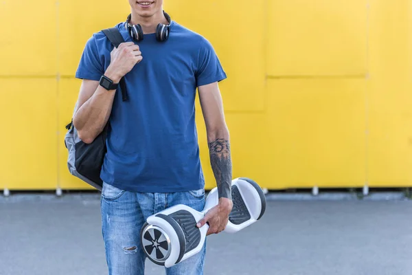 Outgoing teenager holding hoverboard in arm — Stock Photo, Image