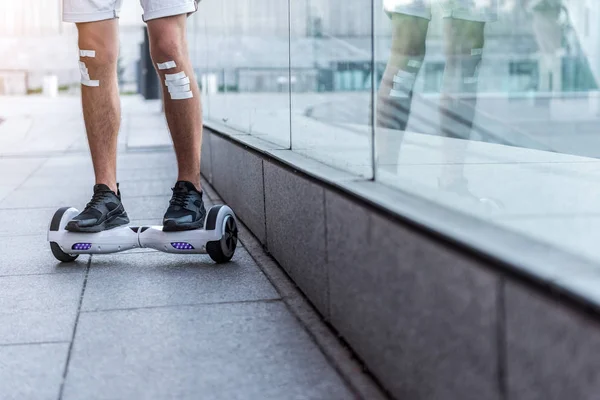 Male legs riding on hoverboard near shop-window — Stock Photo, Image