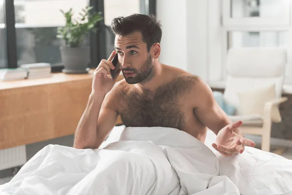 Hombre ocupado usando teléfono inteligente en el dormitorio — Foto de Stock