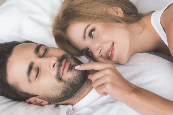 Красивая молодая женщина смотрит, как спит ее муж — стоковое фото