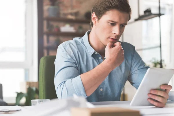 Piacevole attraente giovane uomo sta utilizzando dispositivo moderno — Foto Stock