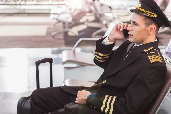 Серьезный взрослый летчик говорит по телефону — стоковое фото