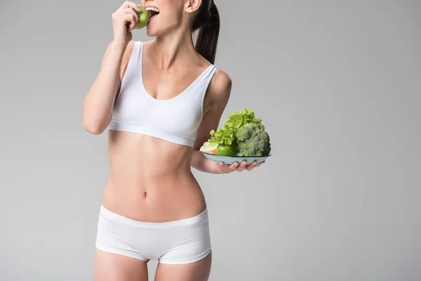Happy young thin woman biting green fruit — Stock Photo, Image