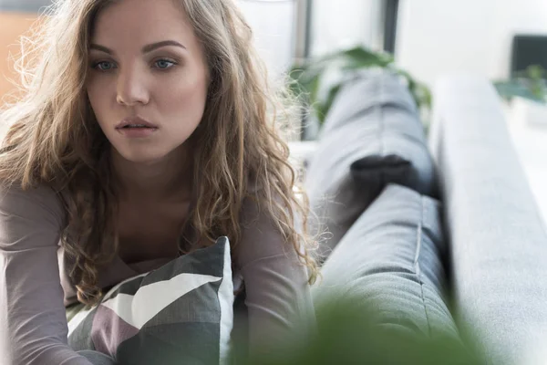 Thoughtful girl locating on comfortable couch — Stock Photo, Image