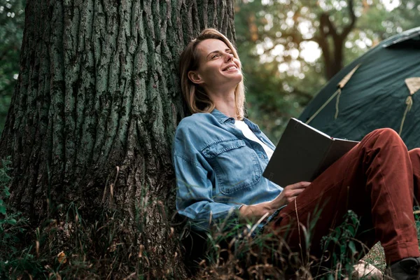 Mujer feliz leyendo literatura en la naturaleza — Foto de Stock
