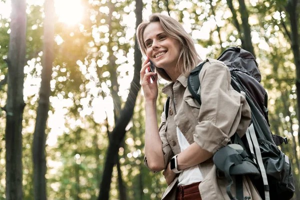 Joven alegre hablando por celular en el bosque — Foto de Stock
