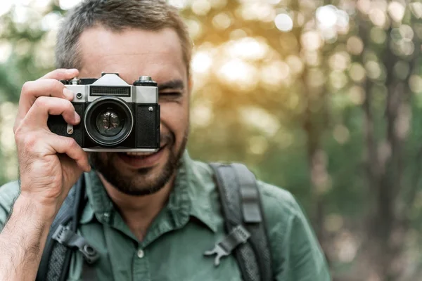 Hombre feliz fotografiando la naturaleza en el bosque — Foto de Stock