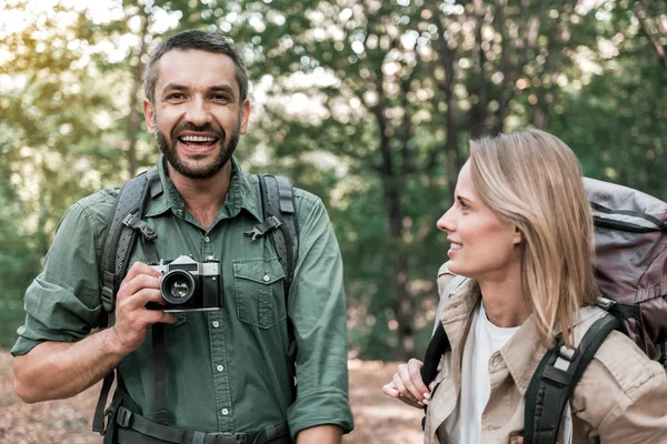 Alegre pareja casada fotografiando bosque durante el viaje — Foto de Stock