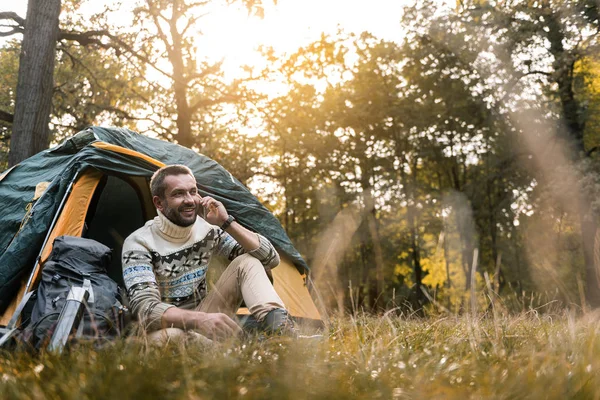 Doğada cellphone tarafından konuşma neşeli erkek turist