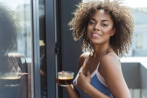 İçecek bir fincan tatma neşeli Afrikalı kadın