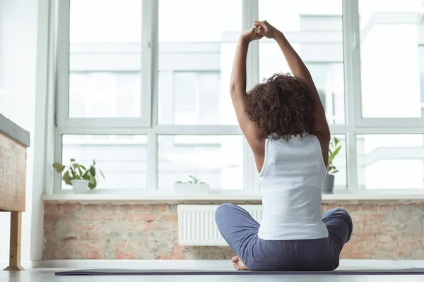 Mulattin praktiziert Yoga auf Matte zu Hause — Stockfoto