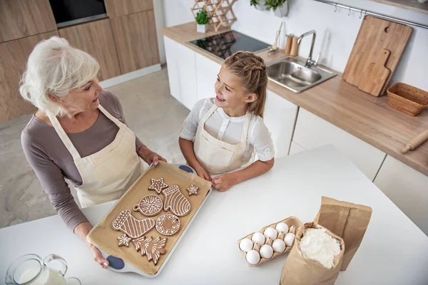 Joyosa abuela sosteniendo bandeja con pastelería dulce —  Fotos de Stock
