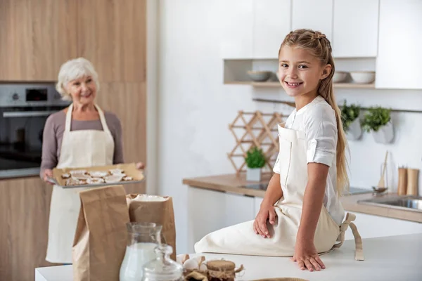 Alegre anciana tratamiento su nieta por dulce pastelería —  Fotos de Stock