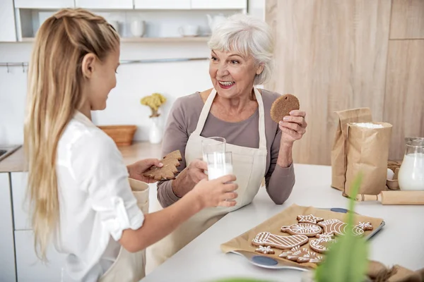 Feliz abuela comiendo pastelería dulce al horno con la nieta —  Fotos de Stock
