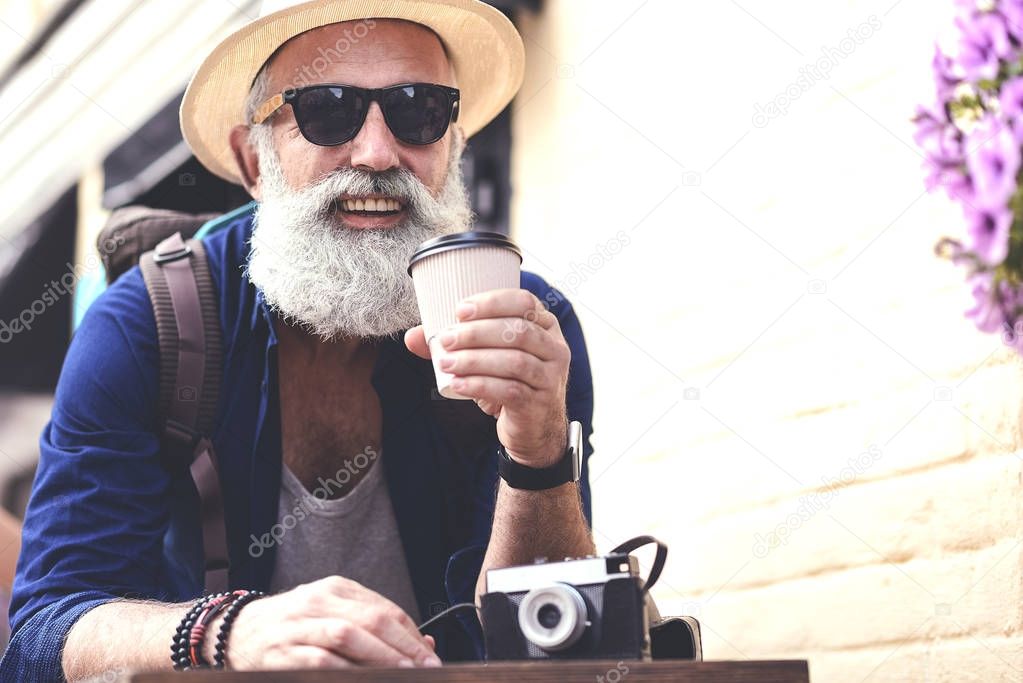 Happy senior male tourist having coffee break