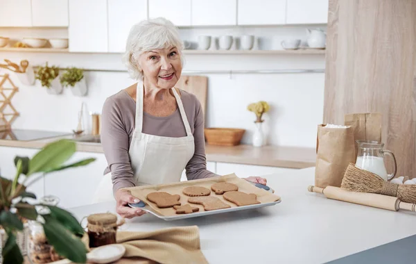 Glückliche alte Frau präsentiert selbstgebackene Plätzchen — Stockfoto