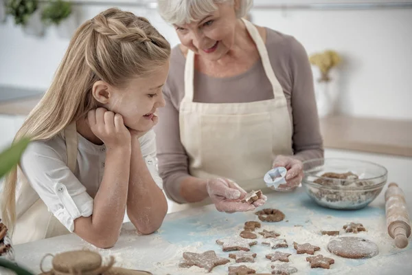 Веселая внучка учится печь выпечку — стоковое фото