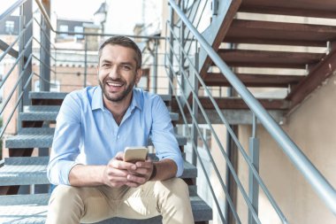 Keyifli sakallı adam dışında istirahat ederken gülümsüyor