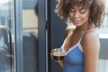 Mutlu genç melez erkek fincan kahve içme