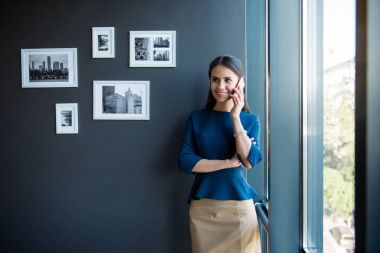 Büyüleyici neşeli iş kadını cep telefonla konuşuyor