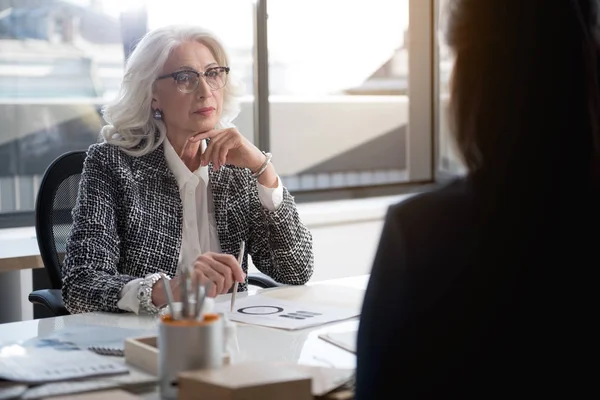 Señora mayor de confianza está trabajando con su joven colega — Foto de Stock