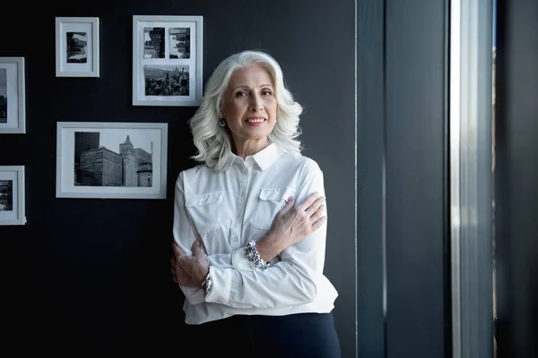 Happy elegant senior woman is standing in office — Stock Photo, Image