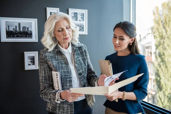 Serious elegante anciana está de pie con su empleado — Foto de Stock