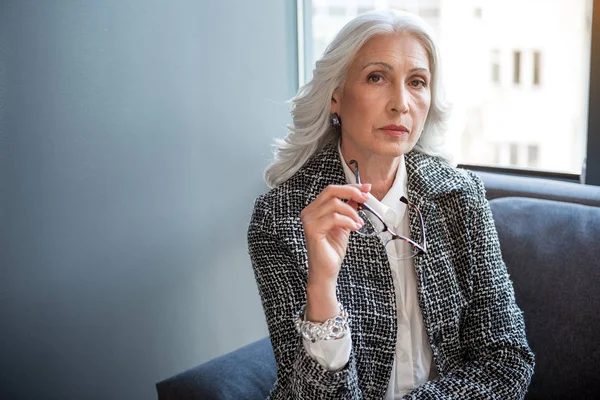 Nachdenkliche alte Frau posiert auf Couch — Stockfoto