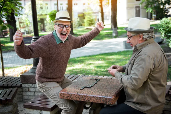 Fröhlicher Rentner gewinnt Dominospiel — Stockfoto