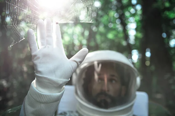 Изумленный космонавт, исследующий новую фауну — стоковое фото