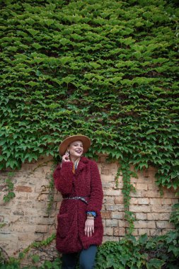 Neşeli kız binasında clambering bitki yakınındaki ayakta