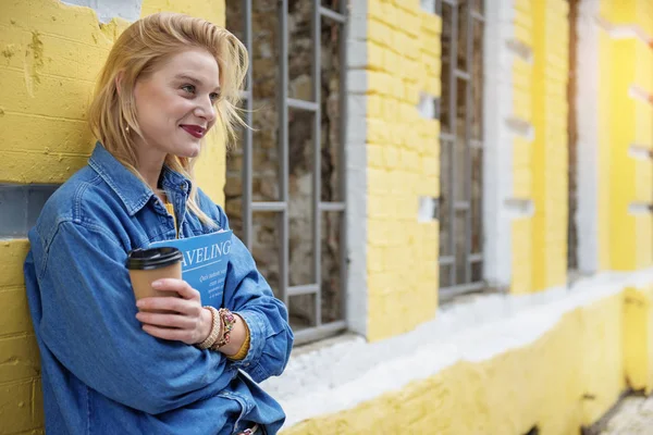 Cheerful blond girl relaxing near yellow building — Stock Photo, Image