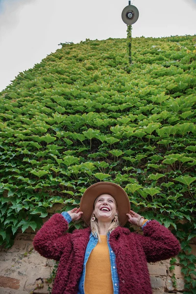 Joyeuse jeune femme regardant les feuilles de lierre avec intérêt — Photo