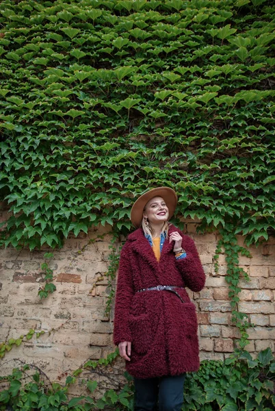 Bina clambering bitki yakın duran neşeli genç kadın