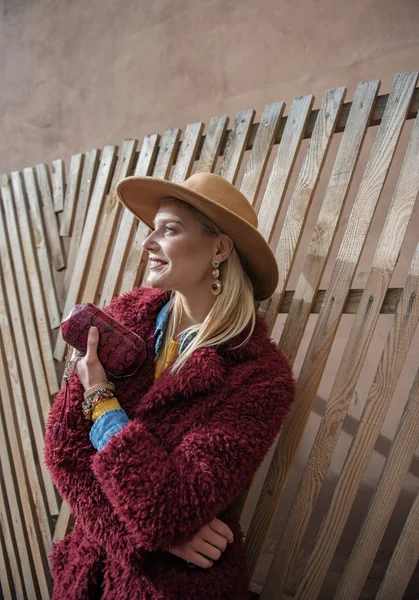 Pretty woman standing near wood palisade on street — Stock Photo, Image