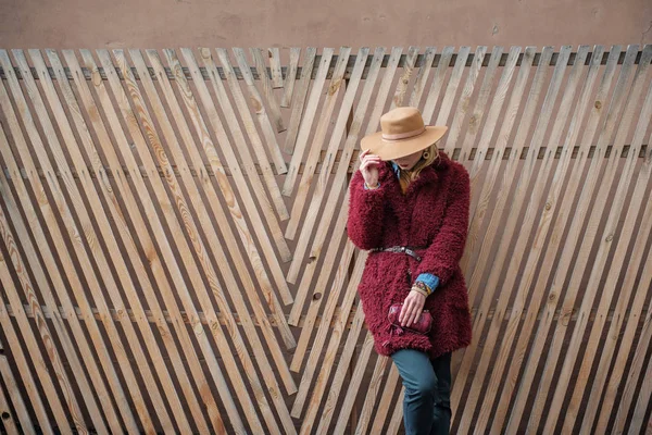 Femme à la mode se détendre près de la palissade en bois — Photo