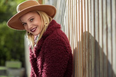 Ahşap çit duran kaygısız genç kadın