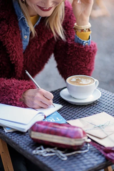 Menina feliz escrevendo em notebook na mesa — Fotografia de Stock