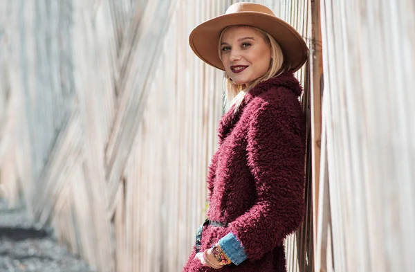 Relaxed blond girl standing near palisade — Stock Photo, Image