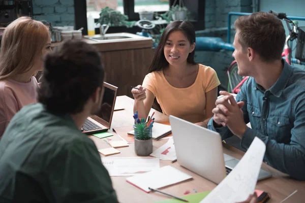 Vrolijke vrouw vertellen met collega 's — Stockfoto